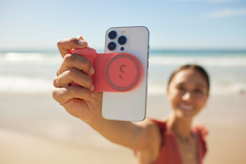 Woman taking selfie with Snap Grip on the beach